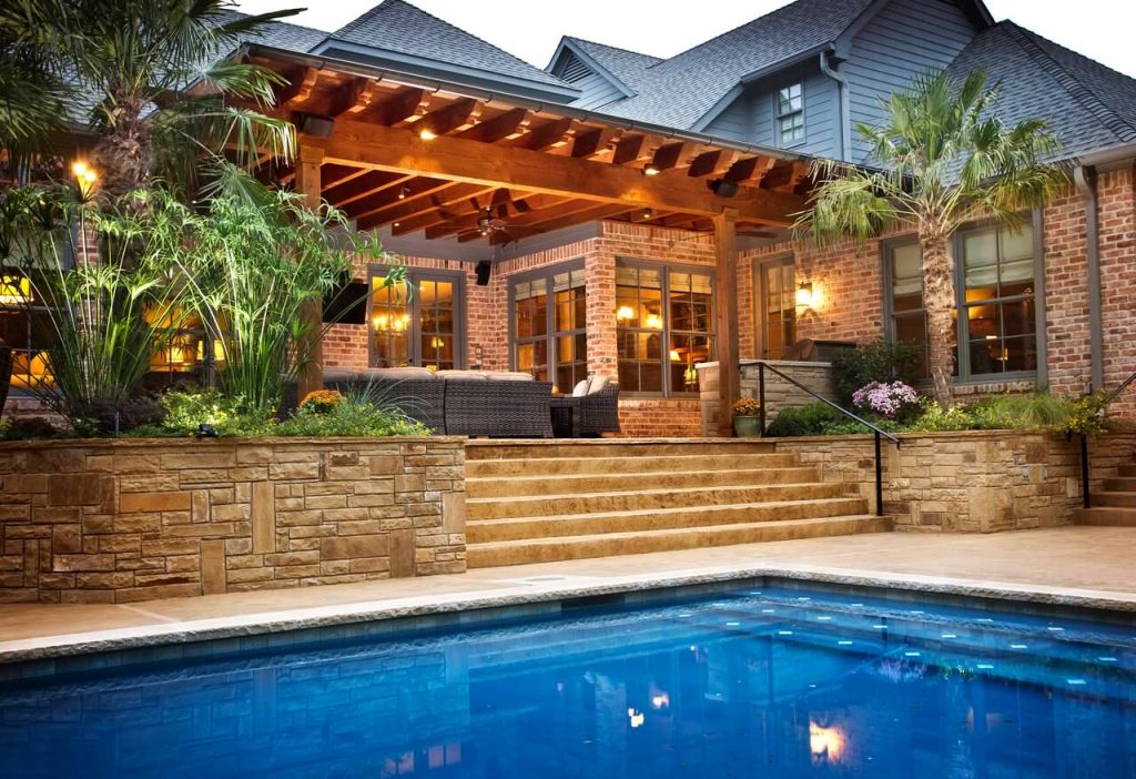 Brick home with outdoor living area covered by pergola